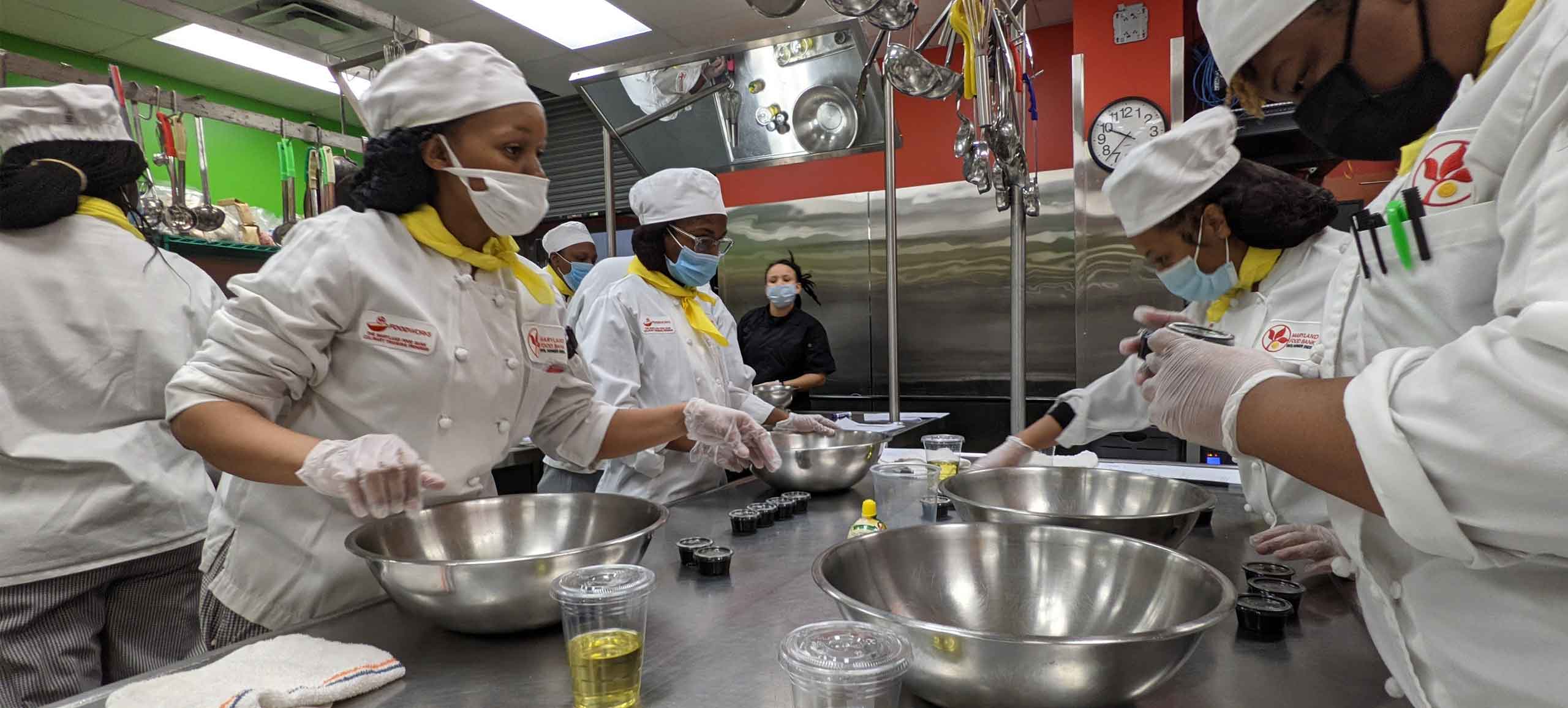 multiple FoodWorks students preparing salad dressing