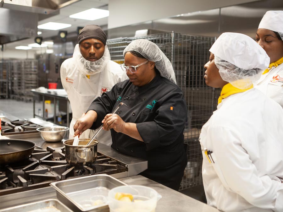 Chef Moe trains FoodWorks students on the stove top