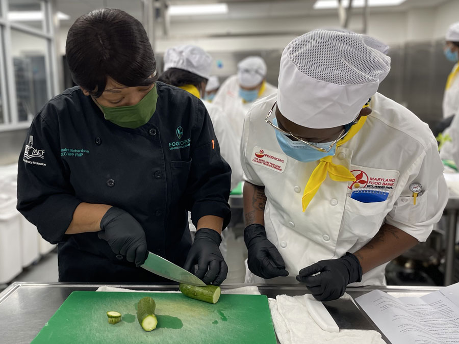 Chef Moe trains FoodWorks student on proper knife usage